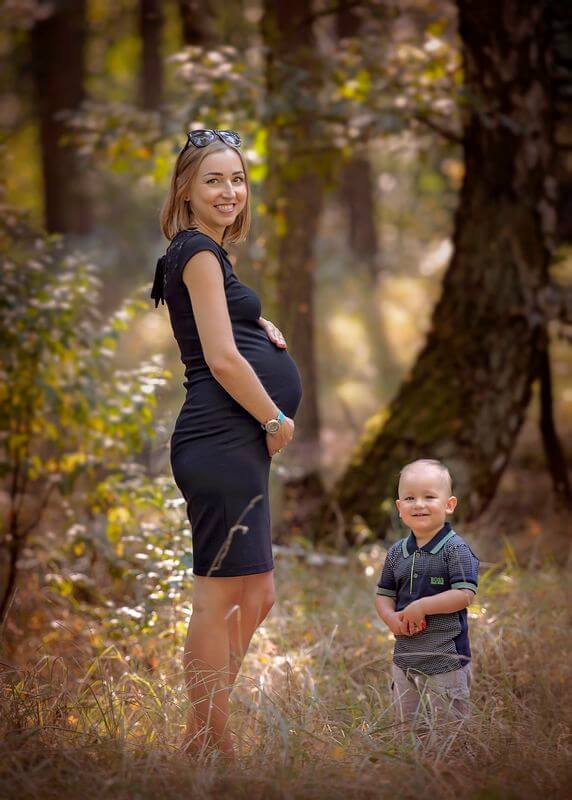kobieta w ciąży w lesie z dzieckiem