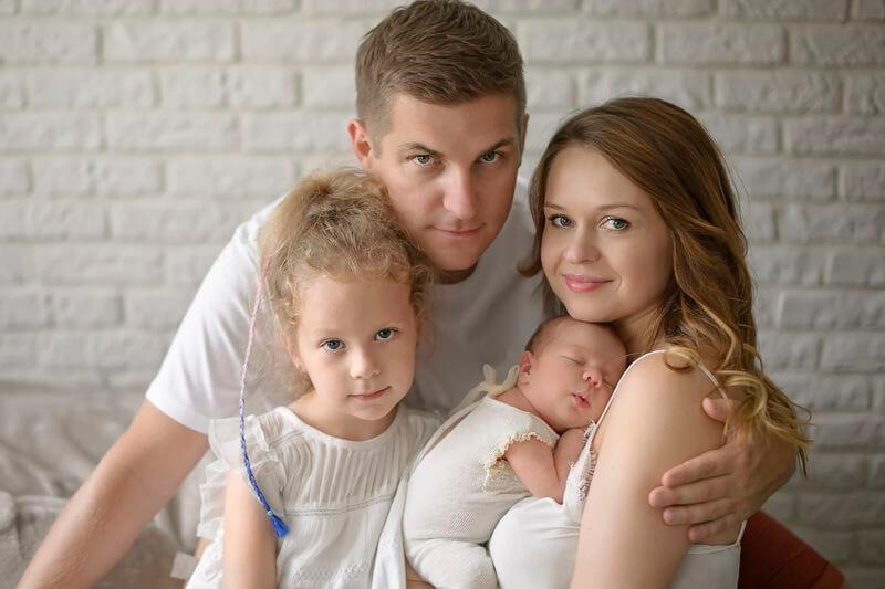 mężczyzna z kobiętą trzymającą noworodka i dziewczynka